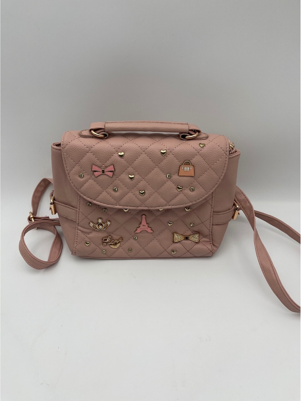 Pink quilted convertible backpack crossbody bag with bow accents